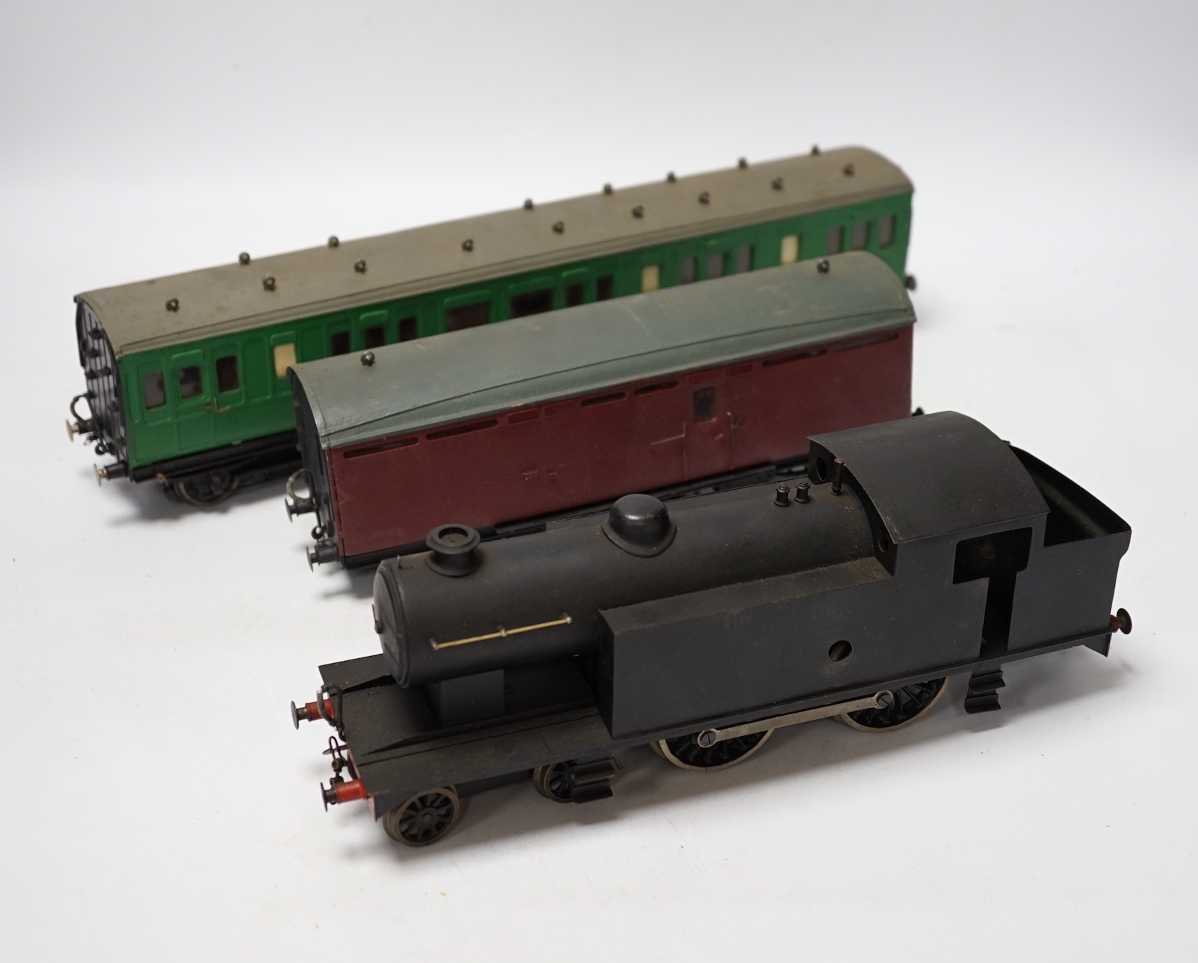 Twenty-five 0 gauge items, including; a kit built clockwork 4-4-2T locomotive with brass body and sprung buffers, together with a kit built Southern Railway bogie coach, a six wheel parcel van and a guard’s van, twenty b
